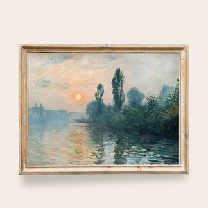 Puede incluir: Una pintura enmarcada que representa una escena de paisaje con un río, árboles y un sol poniente. El cielo es de un azul y rosa suave, y el agua es de un azul tranquilo y reflectante. Los árboles están silueteados contra el cielo, y el sol es de un naranja brillante.