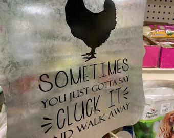 Puede incluir: Un letrero de metal con una silueta negra de un pollo y el texto "SOMETIMES YOU JUST GOTTA SAY CLUCK IT AND WALK AWAY".