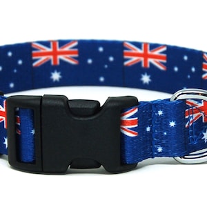 May include: A blue dog collar with a repeating pattern of the Australian flag. The collar has a black plastic buckle and a silver metal D-ring.