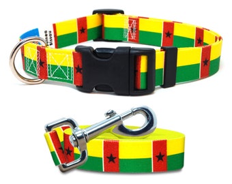 May include: A red, yellow, and green dog collar and leash with the flag of Guinea-Bissau printed on them. The collar has a black plastic buckle and a silver D-ring. The leash has a silver clip.