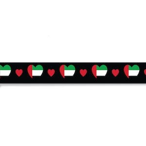 May include: Black and white patterned ribbon with red hearts and green, white, and red heart-shaped flags. The ribbon has a black plastic buckle.