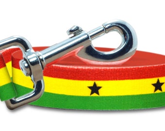 May include: A red, yellow, and green dog leash with a black star pattern. The leash has a silver metal clip.