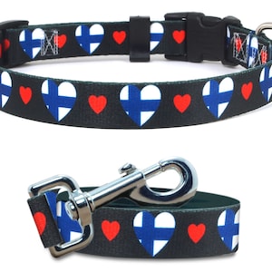 May include: A black dog collar and leash with a repeating pattern of red hearts and white Finnish flags on a black background.