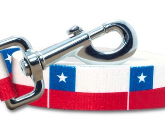 May include: A white, blue, and red dog leash with a silver clip. The leash features the flag of Chile.