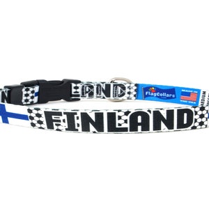 May include: A white and black soccer-themed dog collar with the text "FINLAND" and the Finnish flag on either side. The collar is made by FlagCollars and is labeled "Medium Soccer".