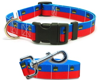 May include: A blue and red dog collar and leash with a repeating pattern of the flag of Liechtenstein. The collar has a black plastic buckle and a gold metal D-ring. The leash has a silver metal clip.