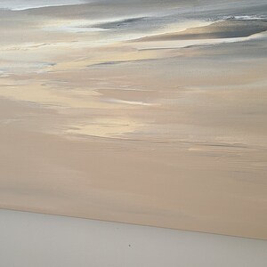 May include: Abstract painting on canvas with a beige background and subtle gray and white brushstrokes. The painting has a soft, dreamy feel.