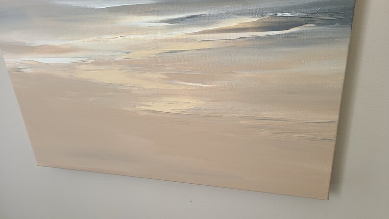 May include: Abstract painting on canvas with a beige background and subtle gray and white brushstrokes. The painting has a soft, dreamy feel.
