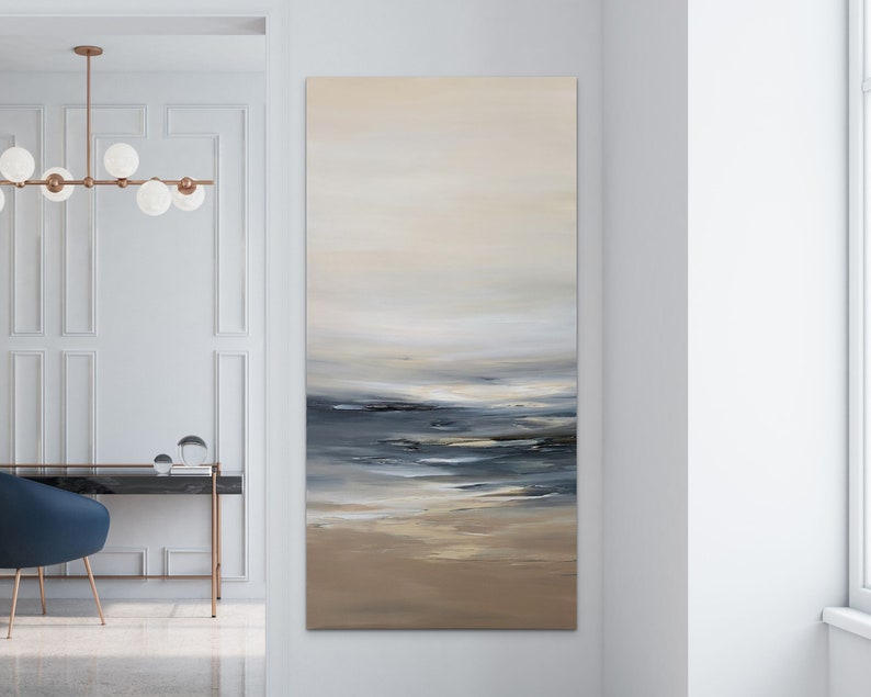 May include: Abstract painting of a seascape with a light blue, gray, and white color scheme. The painting depicts a calm ocean with a sandy beach in the foreground.