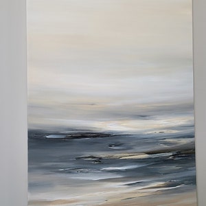 May include: Abstract painting of a seascape with a light blue and gray ocean and a beige sandy beach. The sky is a light beige color with a soft, hazy effect.