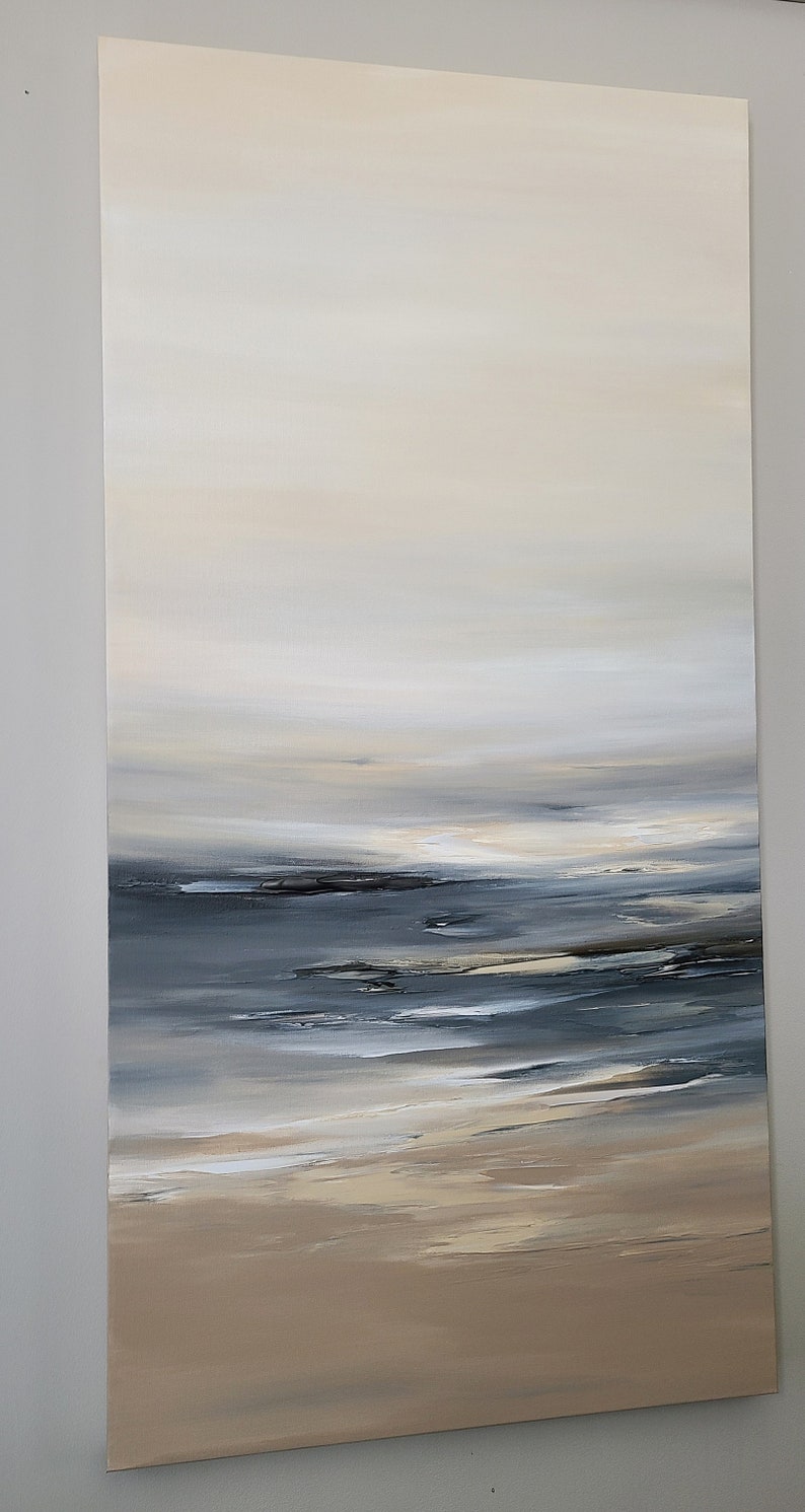 May include: Abstract painting of a seascape with a light blue and gray ocean and a beige sandy beach. The sky is a light beige color with a soft, hazy effect.