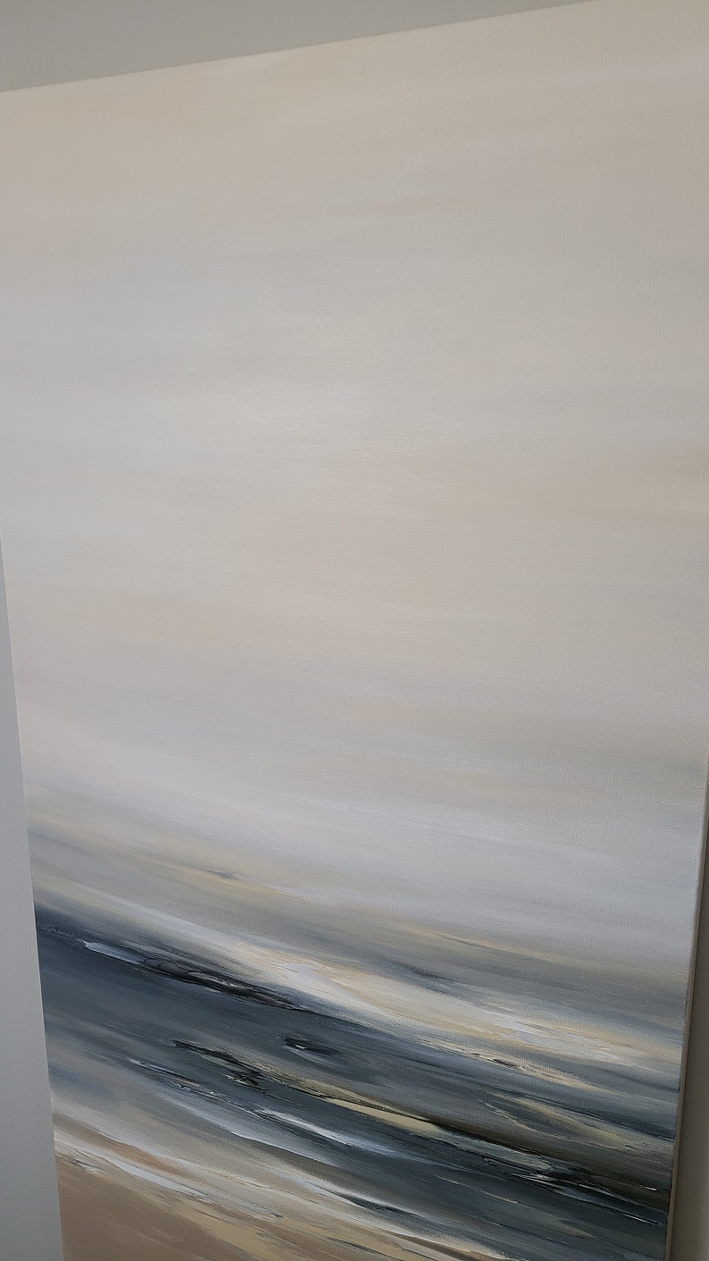 May include: Abstract painting with a horizontal composition. The painting features a gradient of light blue, beige, and white colors, creating a sense of depth and movement. The bottom of the painting features a darker blue color, suggesting a horizon line.