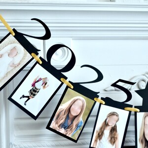 May include: Black and gold graduation banner with photos and the numbers 2023. The banner is strung with gold clips and has a star in the middle.