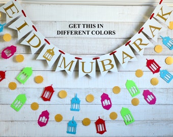 May include: White banner with gold lettering that reads "Eid Mubarak" with red string attached to each flag. The banner is decorated with gold and multi-colored paper lanterns.