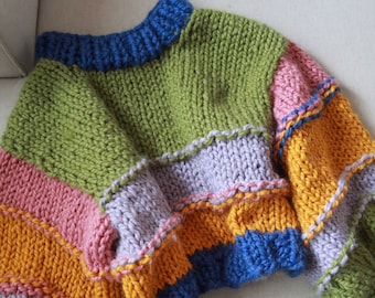 May include: A colorful striped knitted sweater with a crew neck. The sweater is made of a thick yarn and has a relaxed fit.