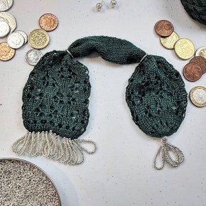May include: A pair of green knitted earrings with silver bead fringe. The earrings are oval shaped and have a delicate lace pattern.