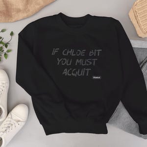 Puede incluir: Sudadera negra con el texto "If Chloe Bit You Must Acquit" en letras blancas. El texto está centrado en la sudadera.