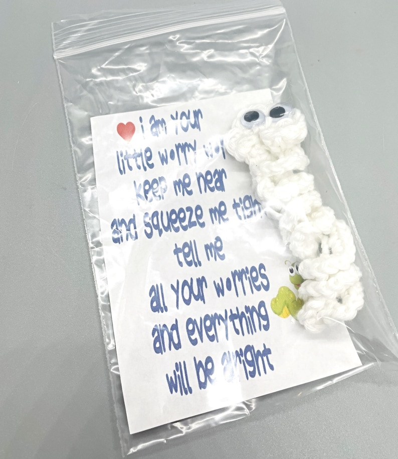 May include: A white crocheted worry worm with googly eyes, packaged in a clear plastic bag. A card inside reads "I am your little worry worm...and everything will be alright."