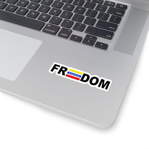 May include: A laptop computer with a sticker that says "FREEDOM" with the Venezuelan flag in the middle of the word.