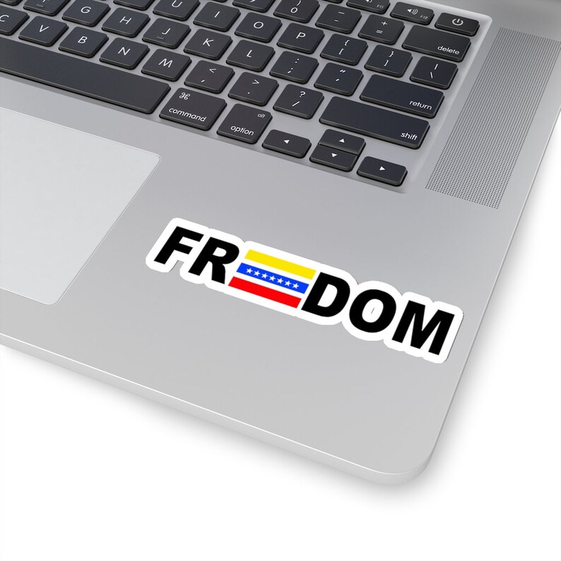 May include: A laptop computer with a sticker that says "FRDOM" with a Venezuelan flag in the middle of the word.