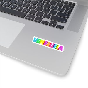 May include: A sticker with the word "VENEZUELA" written in colorful letters on a silver laptop.