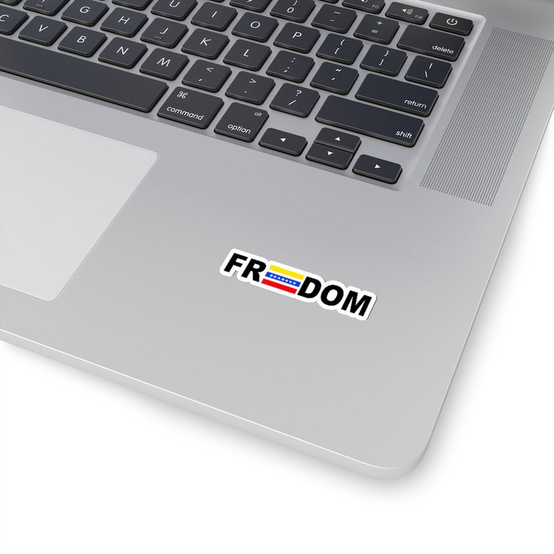 May include: A laptop computer with a sticker that says "FREEDOM" with the Venezuelan flag in the middle of the word.