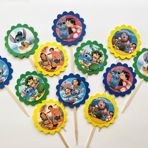 May include: A collection of colorful cupcake toppers featuring characters from the animated movie Lilo & Stitch. Each topper has a scalloped edge in blue, green, or yellow, with images of Stitch, Lilo, and other characters.