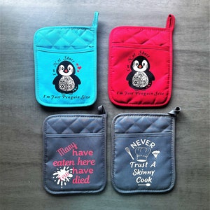 May include: Set of four quilted oven mitts with different designs. Two mitts feature a penguin with the text "I'm Not Short, I'm Just Penguin Size". One mitt features a chef hat with the text "Never Trust A Skinny Cook". The last mitt features a pink splatter with the text "Many Have Eaten Here, Few Have Died."