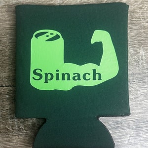 Pode incluir: Resfriador de latas de espuma verde com uma silhueta verde de um b&iacute;ceps flexionando com a palavra "Espinafre" dentro do b&iacute;ceps.