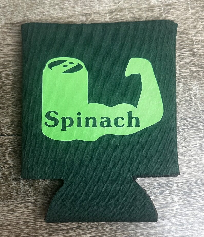 Pode incluir: Resfriador de latas de espuma verde com uma silhueta verde de um b&iacute;ceps flexionando com a palavra "Espinafre" dentro do b&iacute;ceps.