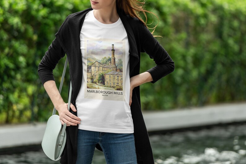 May include: A white t-shirt with a graphic print of a watercolor illustration of a historic mill building. The text "Marlborough Mills" is printed below the image.