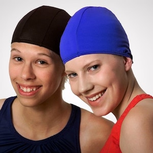 May include: Two people wearing swim caps. One person is wearing a black swim cap and the other is wearing a blue swim cap. Both people are smiling.