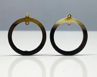 May include: A pair of round, black and brown horn earrings with a gold-colored metal loop at the top.