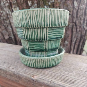 May include: A green ceramic planter with a geometric pattern. The planter has a saucer.