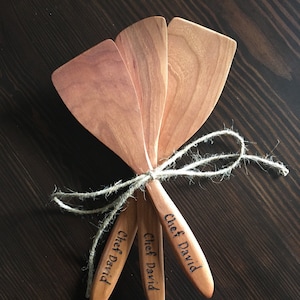 May include: Three wooden spatulas tied together with twine. Each spatula is engraved with the text "Chef David".