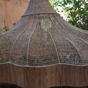 May include: A large, woven, brown, dome-shaped lampshade made of natural materials.