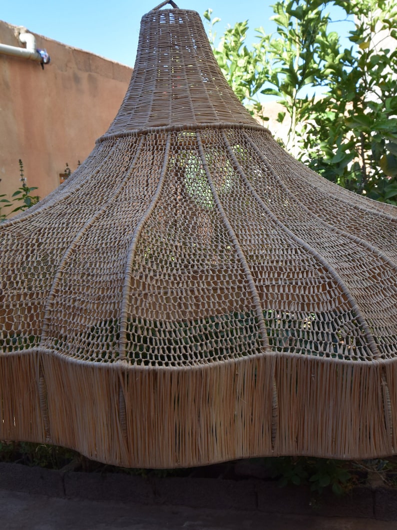 May include: A large, woven, brown, dome-shaped lampshade made of natural materials.