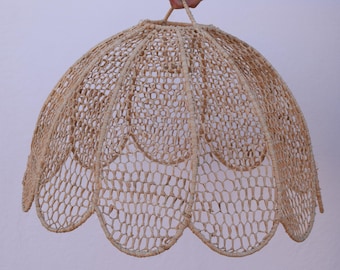 May include: A beige woven lampshade with a scalloped edge. The shade is made of a delicate, open weave material.