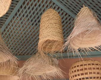 May include: Five woven pendant lights hang from a ceiling with a lattice pattern. The lights are made of natural materials and have a rustic, bohemian style.
