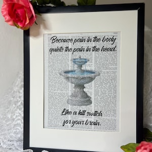 May include: Framed art print featuring a vintage dictionary page with a fountain illustration. The print includes the quote, "Because pain in the body quiets the pain in the head. Like a kill switch for your brain." The frame is black.