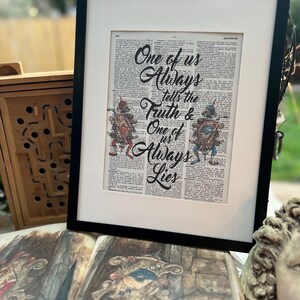 May include: A framed print of a vintage dictionary page with an illustration of two characters. The text reads "One of us Always tells the Truth & One of us Always Lies".