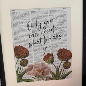 May include: Framed art print featuring a vintage dictionary page background. The print displays the quote "Only you can decide what breaks you" in elegant script, accompanied by floral illustrations in shades of red and pink. The frame is black.