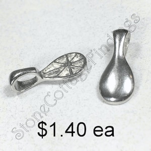 May include: Two silver metal pendant bails with a decorative design. The bail on the left has a starburst design. The bail on the right is smooth.  $1.40 ea