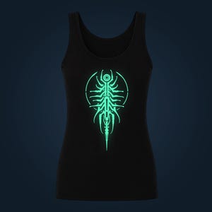 Può includere: Una canotta nera con una stampa grafica luminosa color verde menta chiaro sul petto. Il design è costituito da una struttura simmetrica, allungata, organica e scheletrica racchiusa all'interno di un sottile contorno circolare centrale.