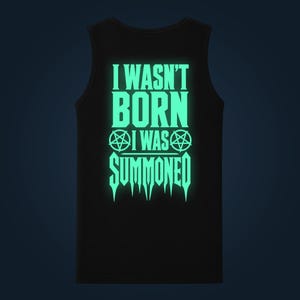 Könnte beinhalten: Ein schwarzes ärmelloses Tanktop mit einem leuchtend mintgrünen Grafikdruck auf der Vorderseite. Der Text lautet I WASN'T BORN I WAS SUMMONED, flankiert von zwei Pentagramm-Symbolen in der Mitte und einer spitzen, tropfenden Schriftart am unteren Rand.