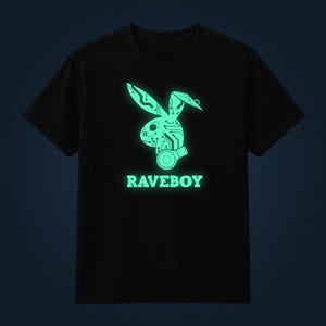 Może przedstawiać: Czarny t-shirt z krótkim rękawem z jasnozieloną, świecącą grafiką przedstawiającą sylwetkę królika wypełnioną wzorami płytek drukowanych i słuchawkami. Pod królikiem znajduje się napis RAVEBOY wykonany pasującą jasnozieloną czcionką.