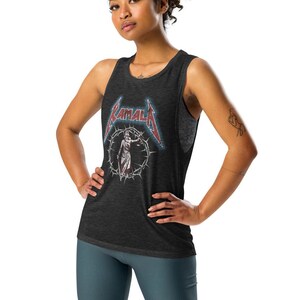 May include: A woman wearing a black tank top with a Metallica logo and dark blue biker shorts. She is standing with her hands on her hips and looking at the camera.