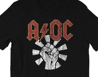 May include: Black t-shirt with a red and yellow graphic of the text "A/OC" with a lightning bolt and a raised fist in a sunburst design.