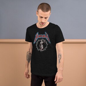May include: A black t-shirt with a graphic print of a woman holding a sword in a circle of thorns. The text "KAMALA" is printed in red above the graphic.