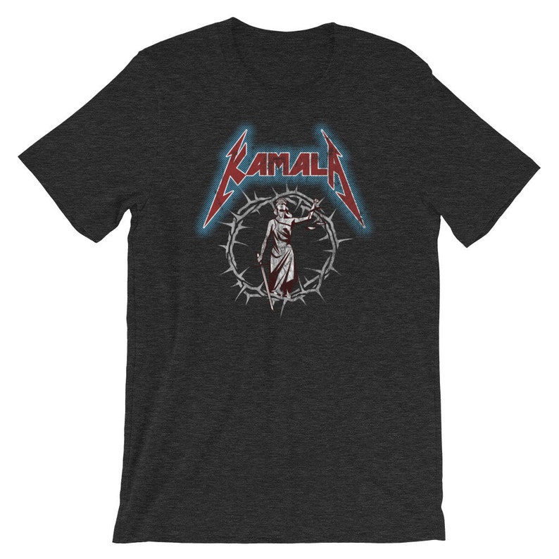 May include: A dark heather grey t-shirt with a red and white graphic of a woman holding scales of justice. The graphic is surrounded by a circle of thorns and the text "KAMALA" is above the graphic.